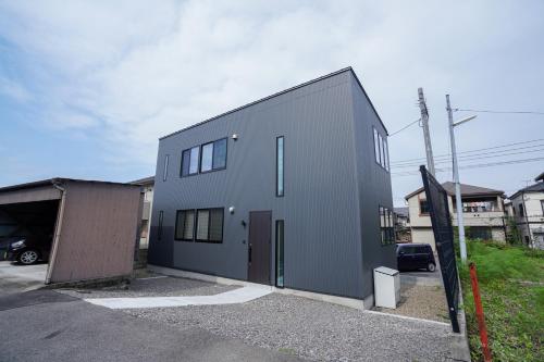 un grande edificio grigio con garage di PrimeRoom別府 SAKURA a Beppu