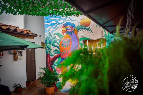 a colorful painting of a parrot on a wall at Hostal Colombian Gold in San Gil