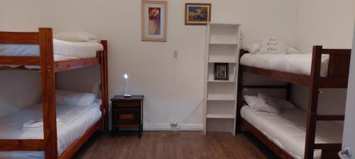 a room with three bunk beds in a room at Hostel La Cumbre Tandil in Tandil