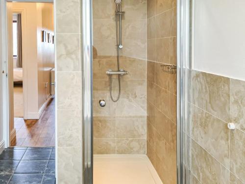 a shower with a glass door in a bathroom at The Old School in Lowick