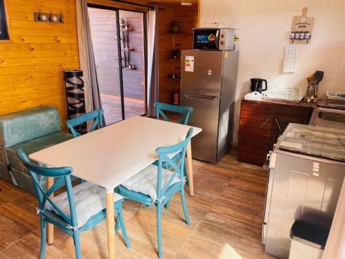a kitchen with a table and chairs and a refrigerator at ELUNEY Combarbala in Combarbalá