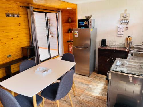 a kitchen with a white table and a refrigerator at ELUNEY Combarbala in Combarbalá