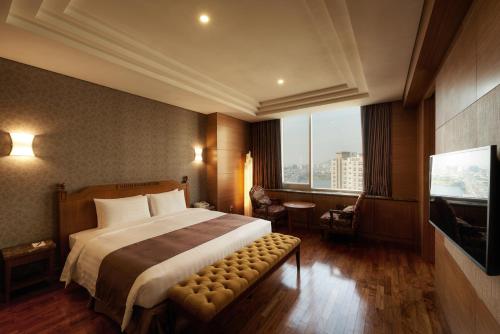 a hotel room with a bed and a television at Seoul Riviera Hotel in Seoul