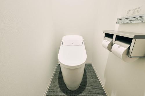 a white toilet in a bathroom with two rolls of toilet paper at OMO3 Tokyo Akasaka by Hoshino Resort in Tokyo