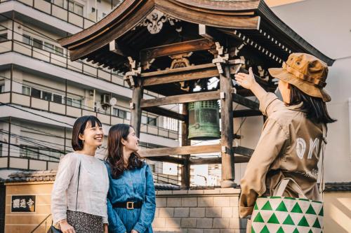 a group of three women standing next to a statue at OMO3 Tokyo Akasaka by Hoshino Resort in Tokyo