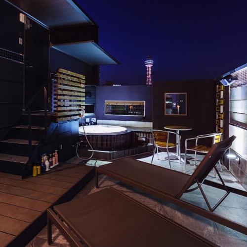 a living room with a table and chairs on a deck at Hotels & Resort Feel in Yokohama