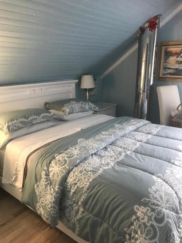 - un grand lit dans une chambre aux murs bleus dans l'établissement gite des iles, à Matane