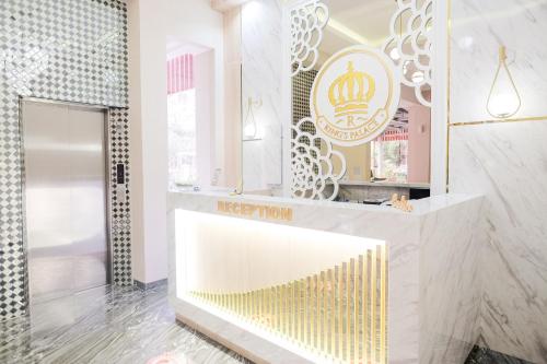 uma loja com um balcão dourado e branco com um espelho em King's Palace Mitra RedDoorz em Medan