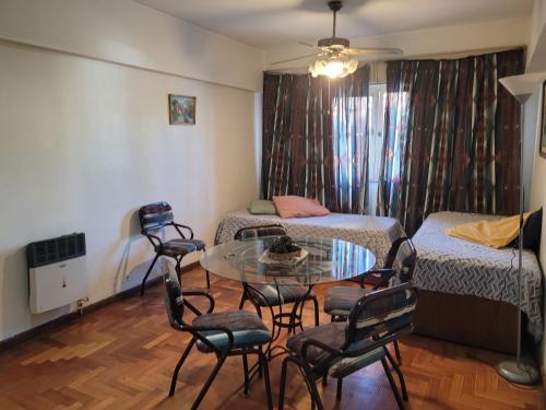Habitación con 2 camas, mesa y sillas en Edificio Independencia Lavalle 35 en Mendoza