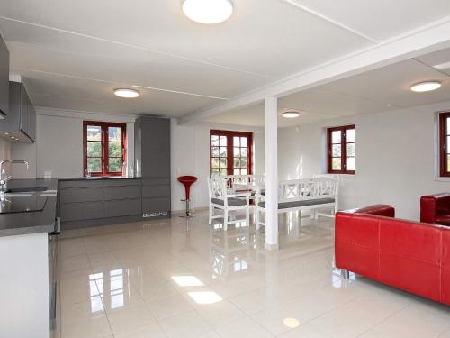 a kitchen and dining room with a red couch at 8 person holiday home in Blokhus in Blokhus