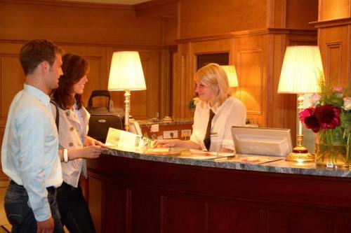 een groep mensen die rond een receptie staan bij Hotel Garni in Bad Schallerbach