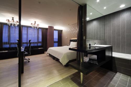 a bedroom with a bed and a desk and a mirror at FX Hotel Taipei Nanjing East Road Branch in Taipei