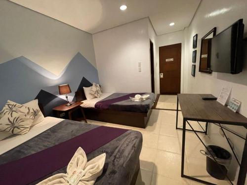 Habitación de hotel con 2 camas y TV de pantalla plana. en Coron Ecolodge en Corón