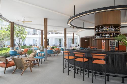 a restaurant with a bar with chairs and tables at Avani Chaweng Samui Hotel & Beach Club - Adults Only in Chaweng