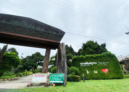 a sign in the grass next to a street at Akantuka Homestay in Chanthaburi