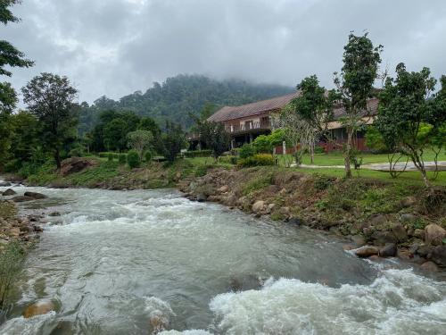 a river in front of a house next to a house at Akantuka Homestay in Chanthaburi