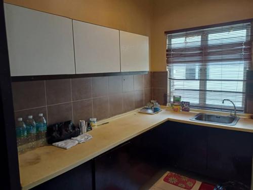 eine Küche mit einer Spüle und einer Arbeitsplatte in der Unterkunft zous homestay in Banting