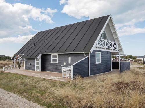 une maison noire avec un toit en gambrel sur une plage dans l'établissement 8 person holiday home in Thisted, à Thisted