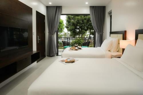 a hotel room with two beds and a television at DAD Resort Phú Quốc in Phu Quoc