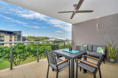 a balcony with a table and chairs and a couch at Oceania at Darwin Waterfront in Darwin