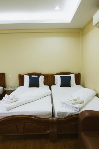 two beds sitting next to each other in a room at Akantuka Homestay in Chanthaburi
