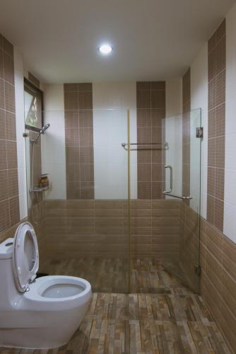 a bathroom with a glass shower and a toilet at Akantuka Homestay in Chanthaburi