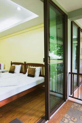 a bedroom with two beds and sliding glass doors at Akantuka Homestay in Chanthaburi