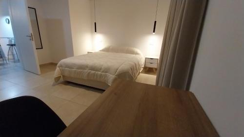 a bedroom with a bed and a wooden table at Adrogue Apart Airport Shuttle 24hs in Burzaco