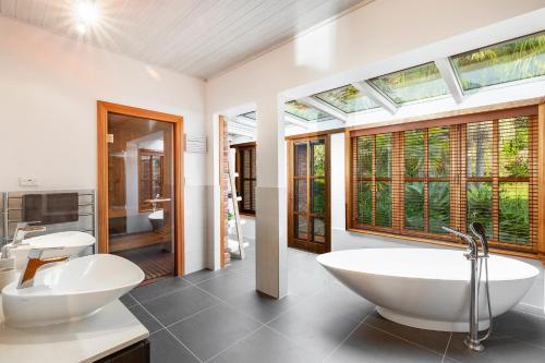 een badkamer met 2 wastafels en een bad bij Peace-Realm Retreat in Matakana