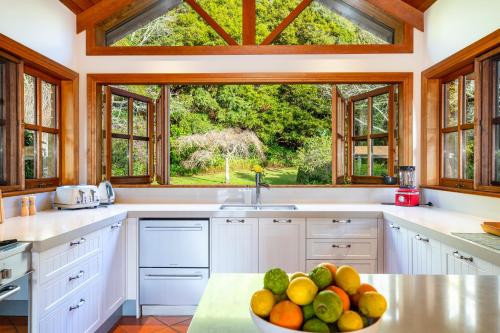 a kitchen with a bowl of fruit on a counter at Peace-Realm Retreat in Matakana