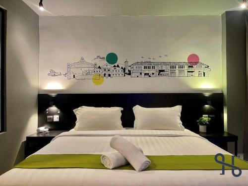 a bedroom with a large bed with green and white sheets at Homesuite' Home at Aeropod SOVO in Kota Kinabalu