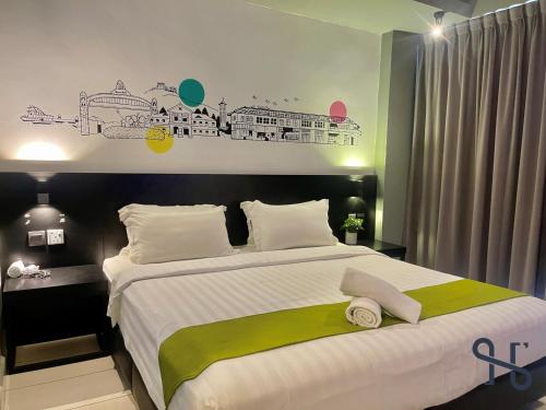 a bedroom with a large bed with a green and white blanket at Homesuite' Home at Aeropod SOVO in Kota Kinabalu