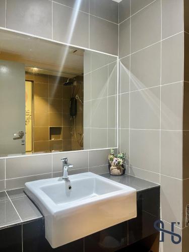 a bathroom with a white sink and a mirror at Homesuite' Home at Aeropod SOVO in Kota Kinabalu