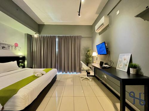 a bedroom with a bed and a desk and a television at Homesuite' Home at Aeropod SOVO in Kota Kinabalu