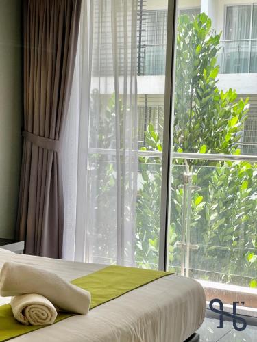 a bed in a room with a large window at Homesuite' Home at Aeropod SOVO in Kota Kinabalu