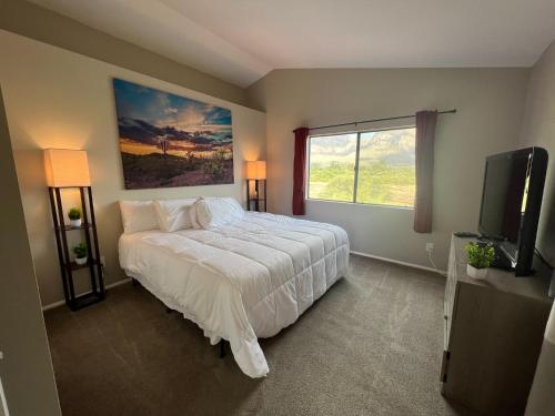 a bedroom with a large bed and a window at The Desert Oasis at #LambertPark Tucson - 4BD + Unobstructed Mountain Views in Tucson