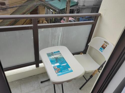 a white chair sitting next to a window at Salcedo's Units in Baguio