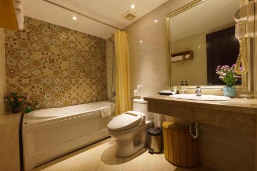 a bathroom with a tub and a toilet and a sink at Roseland Corp Hotel in Ho Chi Minh City