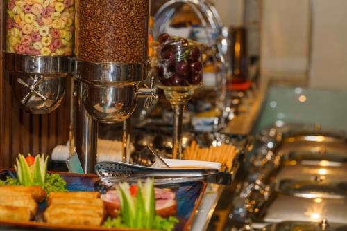 een tafel met een bord eten en een glas wijn bij Roseland Corp Hotel in Ho Chi Minh-stad