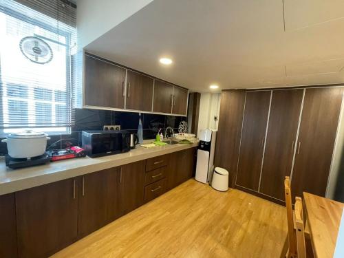 a kitchen with wooden cabinets and a wooden floor at Grand Illusyin in Shah Alam