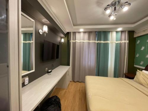 a bedroom with a bed and a tv and a window at Grand Illusyin in Shah Alam