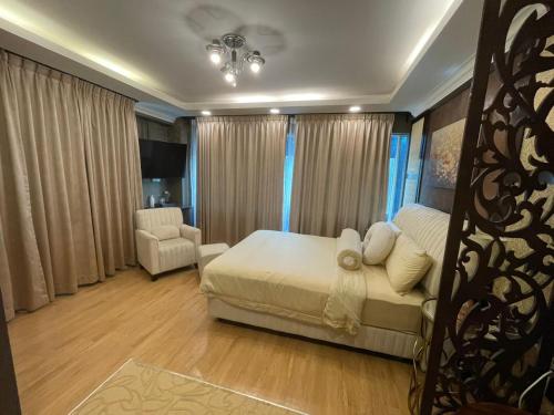 a bedroom with a bed and a chair in it at Grand Illusyin in Shah Alam
