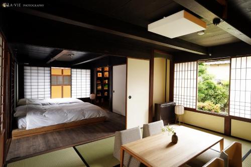 una camera con letto, tavolo e sedie di NIPPONIA HARIMA FUKUSAKI ZOUSHONO YAKATA a Fukusaki