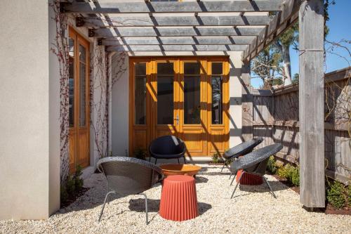 a patio with chairs and a table and a wooden door at Rochville - Luxe, Dog Friendly Townhouse, Kyneton in Kyneton