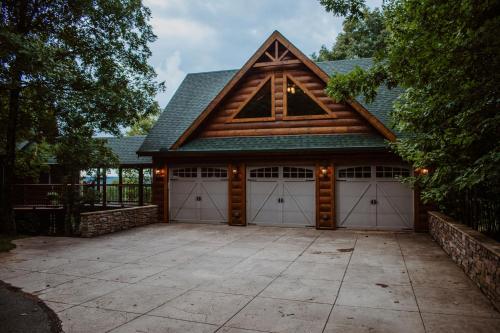 a carriage house with two garage doors and a roof at Treetop Hideaway at Barr5 Ranch in Dunlap