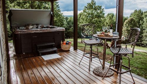 eine Terrasse mit einem Grill, einem Tisch und Stühlen in der Unterkunft Treetop Hideaway at Barr5 Ranch in Dunlap