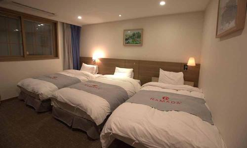 a hotel room with two beds in a room at Ramada Taebaek Hotel in Taebaek