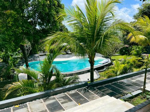 a swimming pool with a palm tree and stairs at ONAYA Bali Resort - Adults Only in Uluwatu