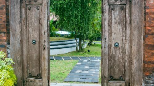 an open door to a garden with a brick wall at ONAYA Bali Resort - Adults Only in Uluwatu