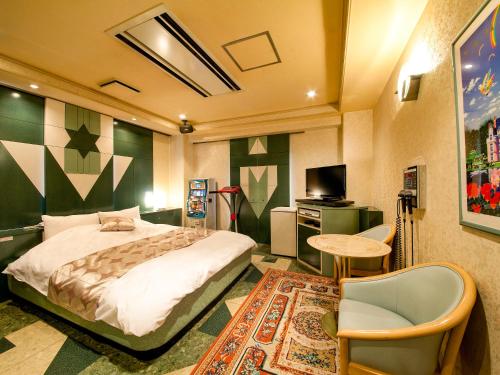 a bedroom with a bed and a table and a tv at Saint martin (Adult Only) in Kyoto
